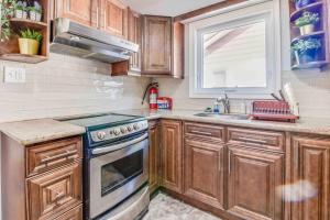 a kitchen with wooden cabinets and a stove and a window at Beautiful house near bluffers beach, 25 minutes to Toronto Downtown, free parking, and wifi in Toronto