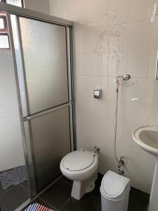 a bathroom with a shower with a toilet and a sink at Quartos em casa no Clelia Bernardes in Viçosa