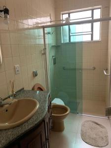 a bathroom with a shower and a sink and a toilet at Quartos em casa no Clelia Bernardes in Viçosa