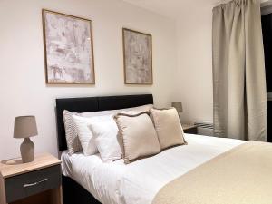 Schlafzimmer mit einem Bett mit weißer Bettwäsche und Kissen in der Unterkunft Marsh House - 2 bedroom apartment in the Heart of the City in Bristol