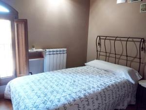 1 dormitorio con 1 cama con edredón blanco en Apartament Santa Anna, en Montblanc