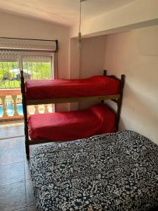 1 dormitorio con 2 literas con sábanas rojas en KSA KMPO en El Carmen