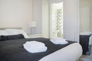 a white bedroom with towels on a bed at Falmer Serene Getaway, Newly Refurbished, Sleeps 4 in Darlington