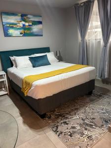 a bedroom with a large bed with a painting on the wall at Circa Apartment 86 in Pretoria