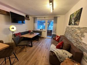 ein Wohnzimmer mit einem Sofa und einem Tisch in der Unterkunft Berghof Haselsberger Appartements in Sankt Johann in Tirol