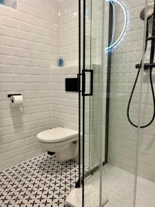 a bathroom with a toilet and a glass shower at Studio Apartment Dandelion in Bratislava