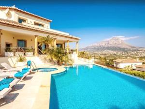 a villa with a swimming pool with a mountain in the background at Casa Orquídea in Jávea