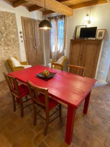 einen roten Tisch und Stühle im Wohnzimmer in der Unterkunft Podere Cereo in Villaga
