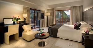 a hotel room with a bed and a desk and chair at Labadi Beach Hotel in Accra