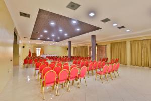 une salle de conférence avec des chaises rouges et une table dans l'établissement Complexe El Bassatine, à Béni Mellal