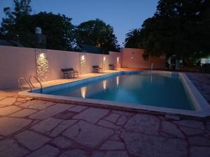 - une piscine dans un jardin la nuit dans l'établissement Los Lirios, à Sierra de los Padres