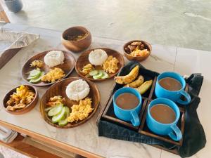 伊洛伊洛的住宿－Balai Lawaan Charming Sanctuary，餐桌,盘子上放着食物和咖啡