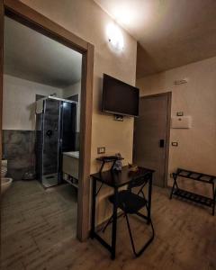 baño con mesa y TV en la pared en Foresteria Del Borgo Etrusco, en Lonato