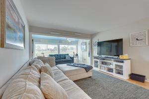 a living room with a couch and a tv at Panama City Beach Bay Point Condo Close to Golf! in Panama City Beach
