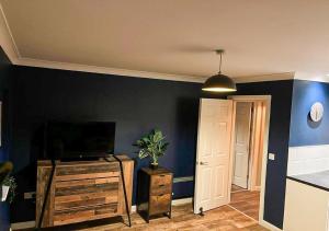 sala de estar con TV y pared azul en Stylish & Modern Apartment - Southend Stays, en Southend-on-Sea