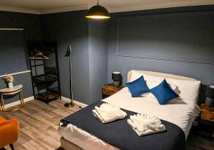 een slaapkamer met een bed met blauwe en witte kussens bij Chic Coastal Hideaway: 2-BR Gem Southend Stays in Southend-on-Sea