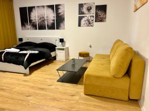 a bedroom with a bed and a couch and a table at Studio Apartment Dandelion in Bratislava
