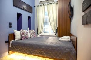 Un dormitorio con una cama con paredes azules y una ventana en Deisisroom nafplio Afroditi, en Nauplia