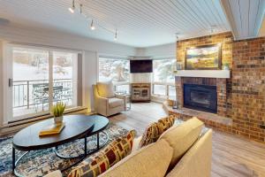 a living room with a couch and a fireplace at Dulany at the Gondola in Steamboat Springs