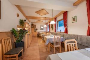 a restaurant with tables and chairs in a room at Landhaus Hofer in Neustift im Stubaital