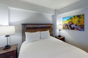 a bedroom with a large white bed and two lamps at Dulany at the Gondola in Steamboat Springs