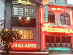 a building with neon signs on the side of it at Appartement Mac Auliffe in Bastogne