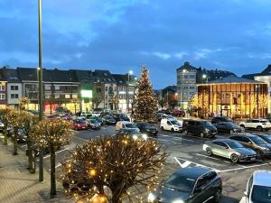 a parking lot filled with cars and a christmas tree at Appartement Mac Auliffe in Bastogne