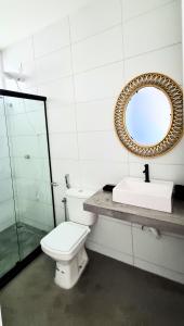 uma casa de banho com um WC e um espelho. em Casa.Km0 em Rio das Ostras
