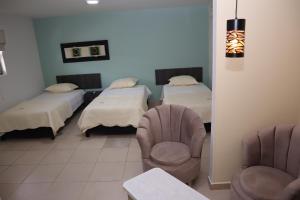 una habitación de hospital con 2 camas y una silla en Hotel Ali Jose, en Albania