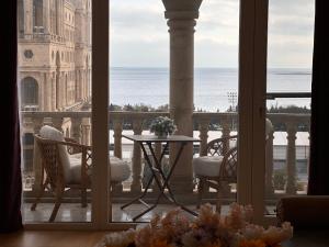 a room with a balcony with a table and chairs at Sea view Residence in Baku