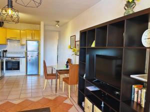 a kitchen and dining room with a table and a refrigerator at Nice apartment Duque Tenerife South in Adeje