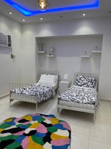 a room with two beds and a rug on the floor at شاليه ضفاف - Difaf Chalet - فخم وجديد وفاخر in Jeddah