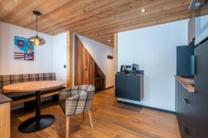 eine Küche und ein Esszimmer mit Tisch und Stühlen in der Unterkunft TARDEVANT 21 in Le Grand-Bornand