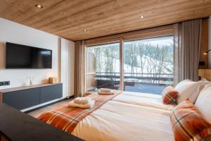 a bedroom with a large bed with a large window at TARDEVANT 21 in Le Grand-Bornand
