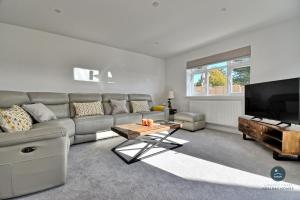 a living room with a couch and a flat screen tv at Days Away - Luxury holiday home in Radipole