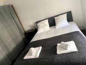 ein Bett mit zwei weißen Handtüchern darüber in der Unterkunft Fée clochette # Centre de Reims in Reims