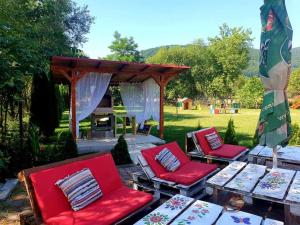 a group of red chairs and a gazebo at Casa langa rau in Bran