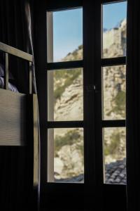 a window with a view of a mountain through it at Helin's Hostel in Berat
