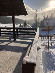 eine schneebedeckte Bank neben einem Zaun in der Unterkunft Mountain resort house - Planinska vikendica in Han Pijesak