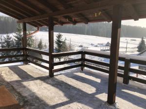ein Holzzaun vor einem schneebedeckten Feld in der Unterkunft Mountain resort house - Planinska vikendica in Han Pijesak + 32 Fotos