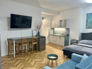 a living room with a kitchen and a table and a couch at Almond Studio Apartment in Bratislava