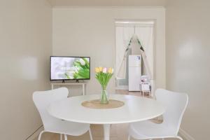 a white dining room with a white table and white chairs at Seoul Sensibility B&B House in Seoul