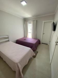 sypialnia z 2 łóżkami i oknem w obiekcie Suíte Premium w mieście Itajaí