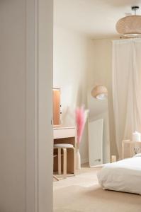 Seoul Sensibility B&B House في سول: غرفة نوم بيضاء مع سرير وطاولة تزيين