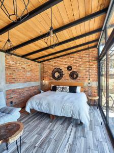 a bedroom with a bed in a brick wall at Cabaña Gardenia, Tapalpa in Tapalpa