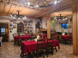 a restaurant with red tables and chairs in a room at Zirgu sēta "Klajumi" - Horse ranch "Klajumi" in Kaplava