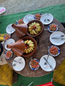 una mesa cubierta con platos y tazones de comida en Eagles Dôme, en Bou Tferda