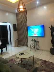 a living room with a flat screen tv on the wall at Luxury apartments in Ibadan