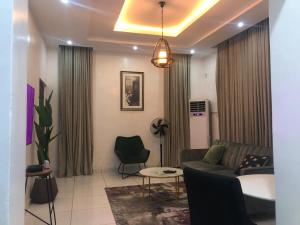 een woonkamer met een bank en een tafel bij Luxury apartments in Ibadan