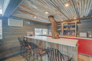 a room with a bar with chairs and a tree at Rustic and Western House on Lake - Swim, Fish, Hunt! in Llano